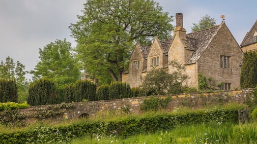 View of priests house across Orchard filled with white flowers